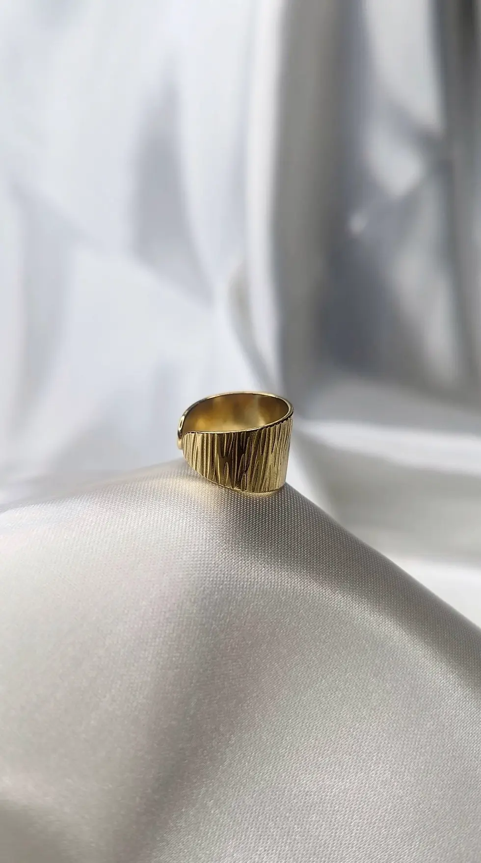 Miniature : gros plan sur une bague anneau doré en acier inoxydable avec une texture martelée et ajustable