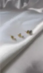 gros plan sur une boucle d'oreille simple à clou sertie d'un diamant, en or jaune