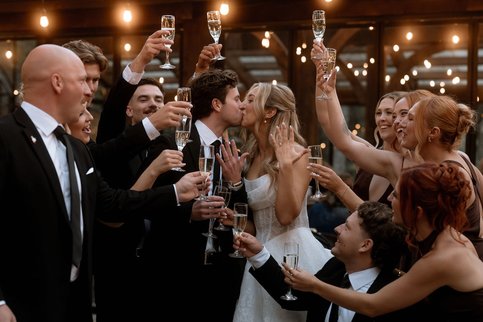 Bride, groom and wedding guests raising champagne glasses during a reception at The Valley.