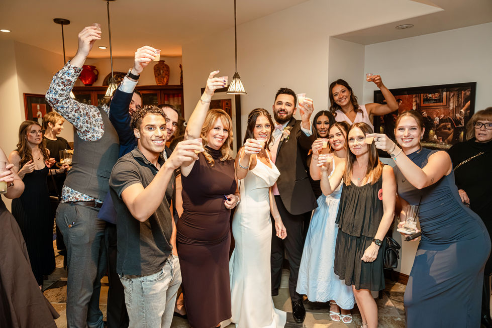Wedding guests raising drinks and celebrating at a private-property wedding reception in Edmonton.