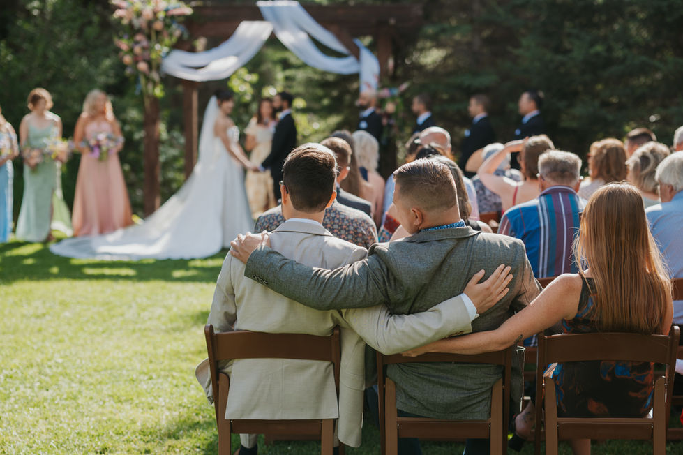 Guests seated for an outdoor forest wedding ceremony at The Valley in Alberta.