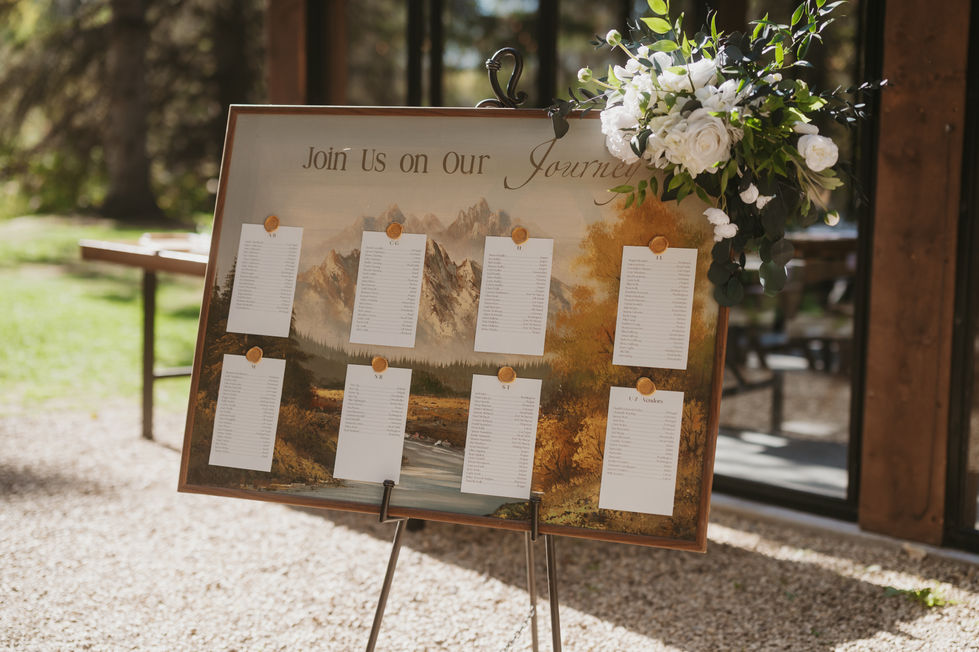 Wedding seating chart displayed on an easel outside The Valley reception venue in Alberta.