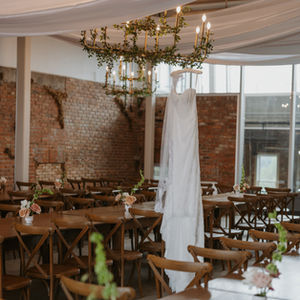Bride’s wedding dress hanging above the reception space at the Pendennis Building in Edmonton.