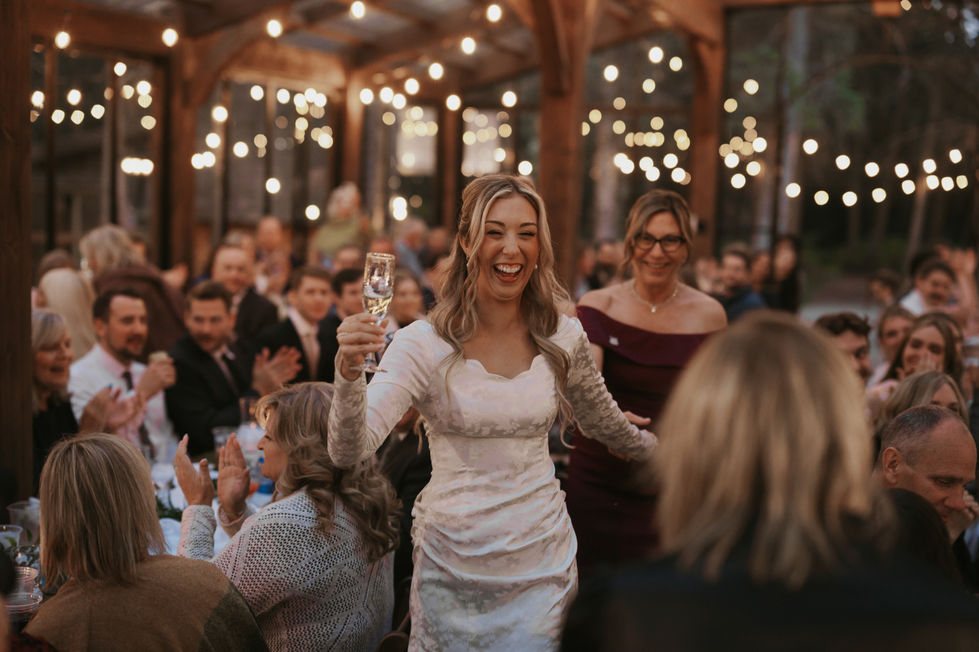Bride raising a glass with wedding guests during a reception at The Valley near Edmonton.