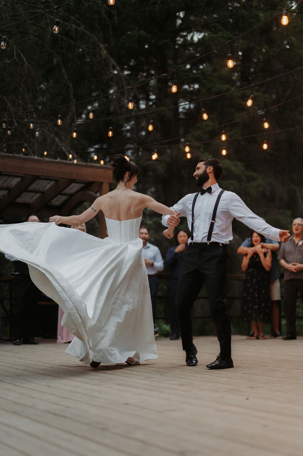 ride and groom dancing beneath string lights during their outdoor wedding reception at The Valley.