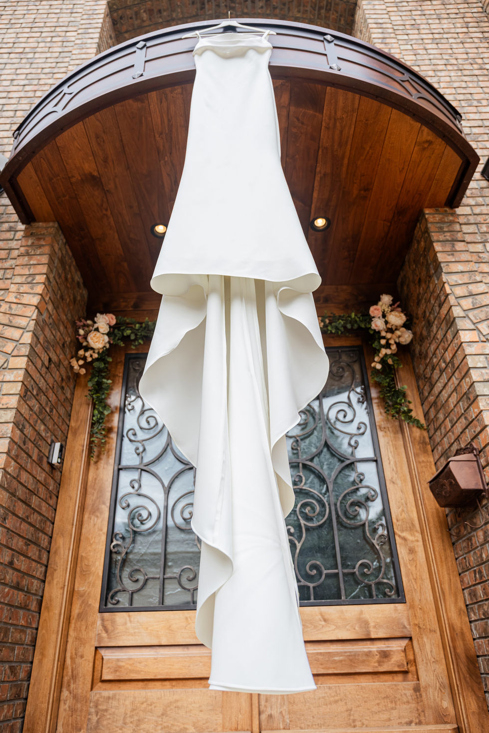 White bridal gown hanging inside a private home before an Edmonton backyard wedding.
