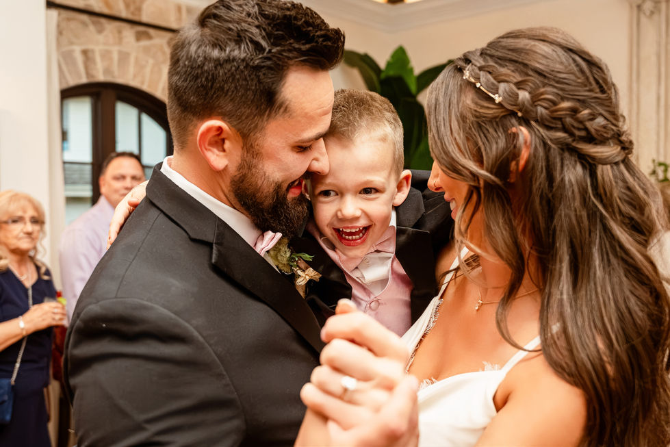Bride and groom dancing with a young boy during their Edmonton wedding reception.