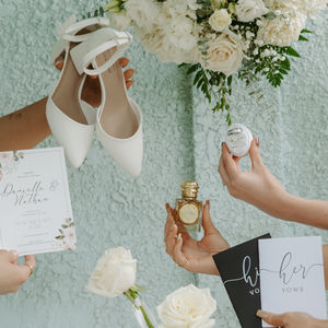Bridal details with white florals, wedding shoes, perfume and stationery at a River’s Edge Devon wedding