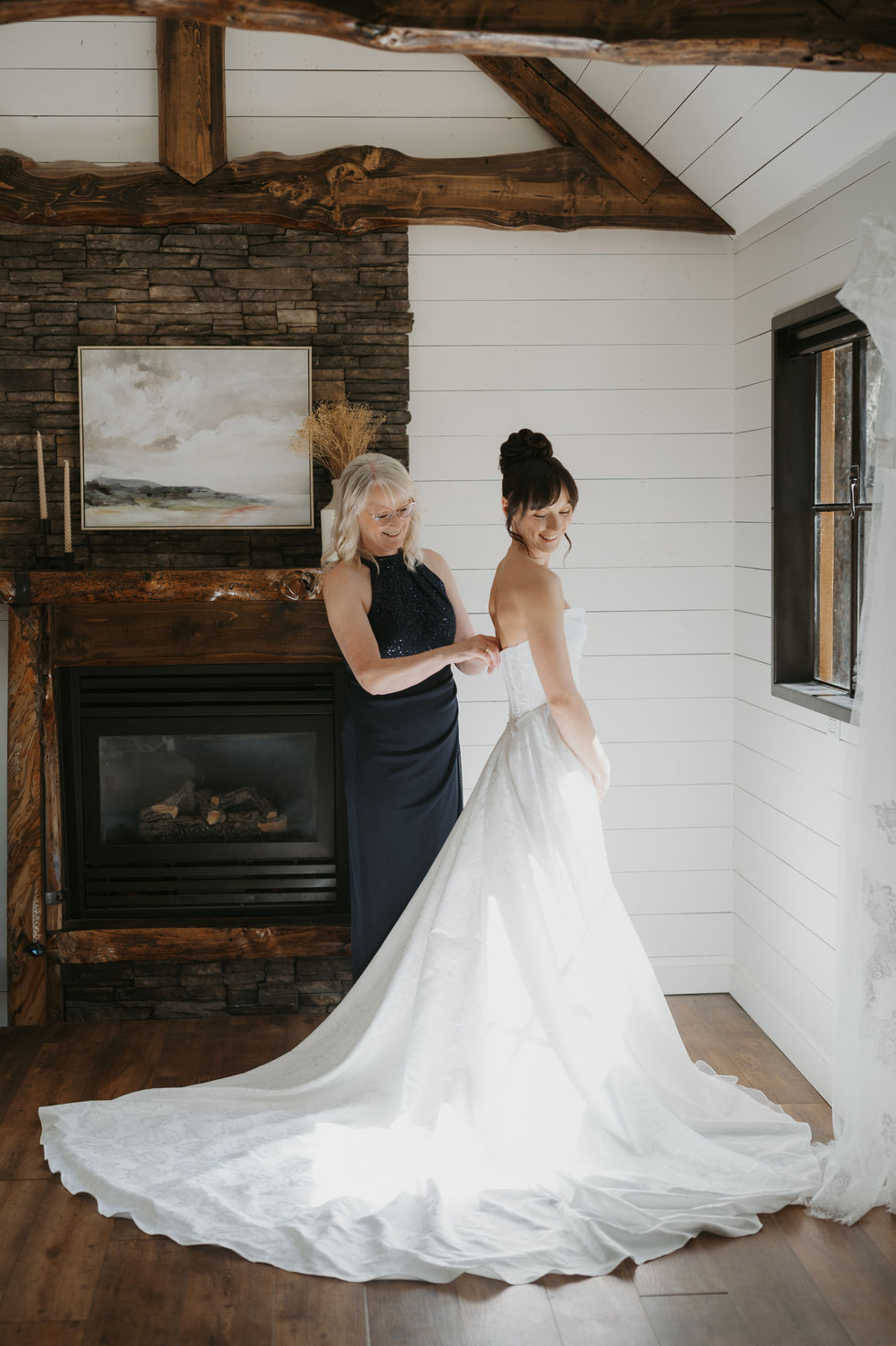 Bride receiving help fastening her wedding dress while getting ready at The Valley.