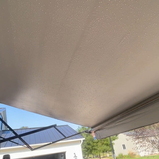 clean rv awning with house and barn in the background