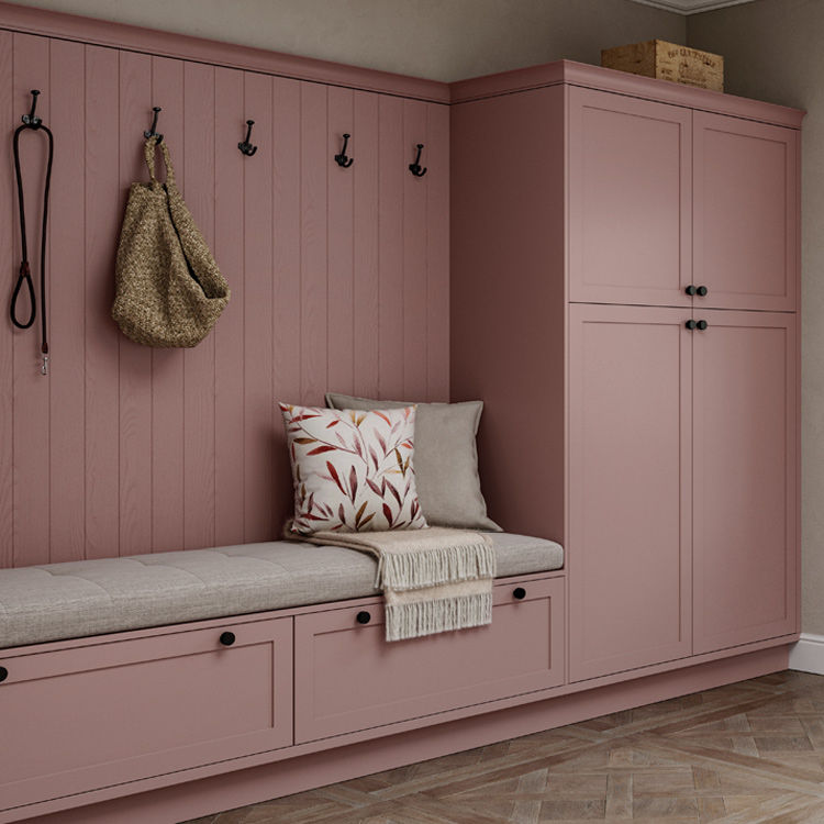 Pink boot room with built in broom cupboard for storage.