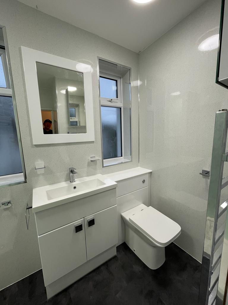 Gloosy Atlanta cabinets, concealed cistern and white framed mirror.