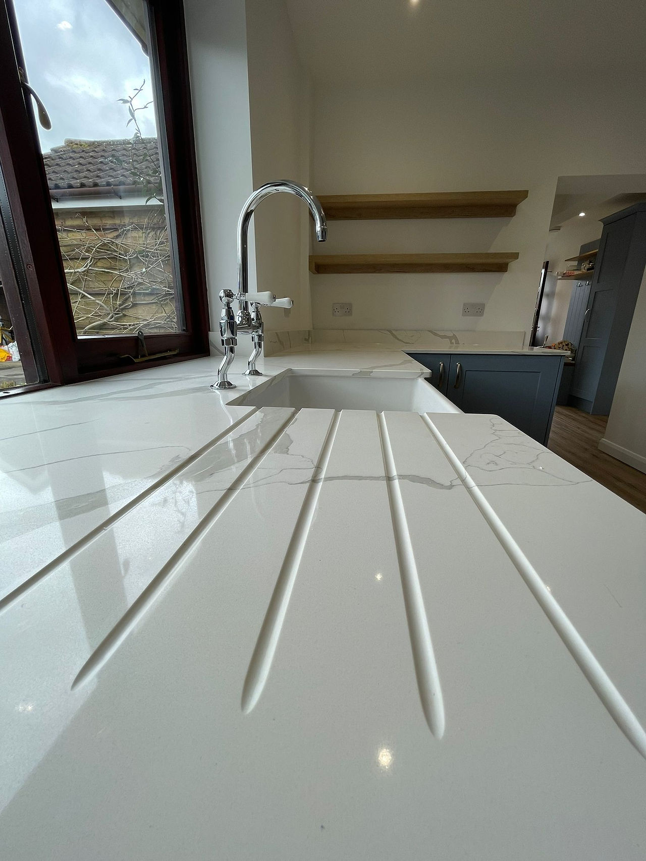 Quartz Calacatta worktop with draining grooves carved into the worktop.