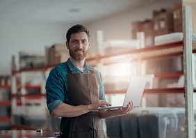 male-worker-working-laptop-background-warehouse.jpg