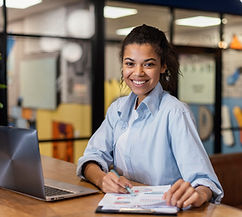 smiley-woman-working-with-laptop-papers-office.jpg
