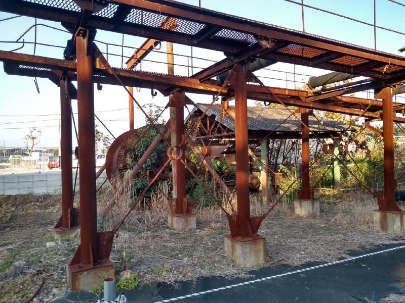 Rusty mine machinery with greery growing around it