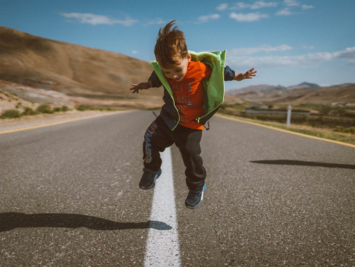 A young child jumping with joy outdoors representing confidence, focus, and early childhood development through music education, kids music lessons, and creative learning at Kingwood Arts Academy of Music in Kingwood, TX.