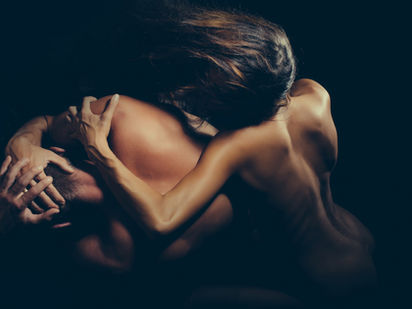 A couple shares an intimate embrace, their forms intertwined in a moment of profound connection.