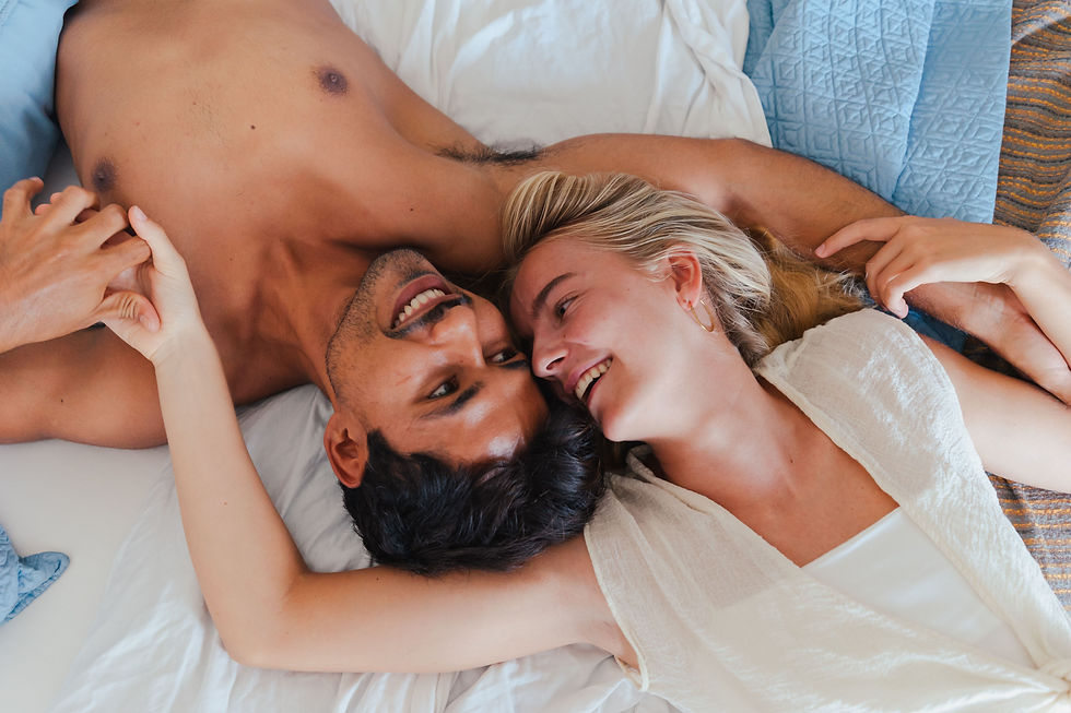 



A couple enjoys a peaceful, intimate moment together, exchanging smiles and holding hands while lying on a cozy bed.

