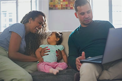A family with a young child sitting on a couch