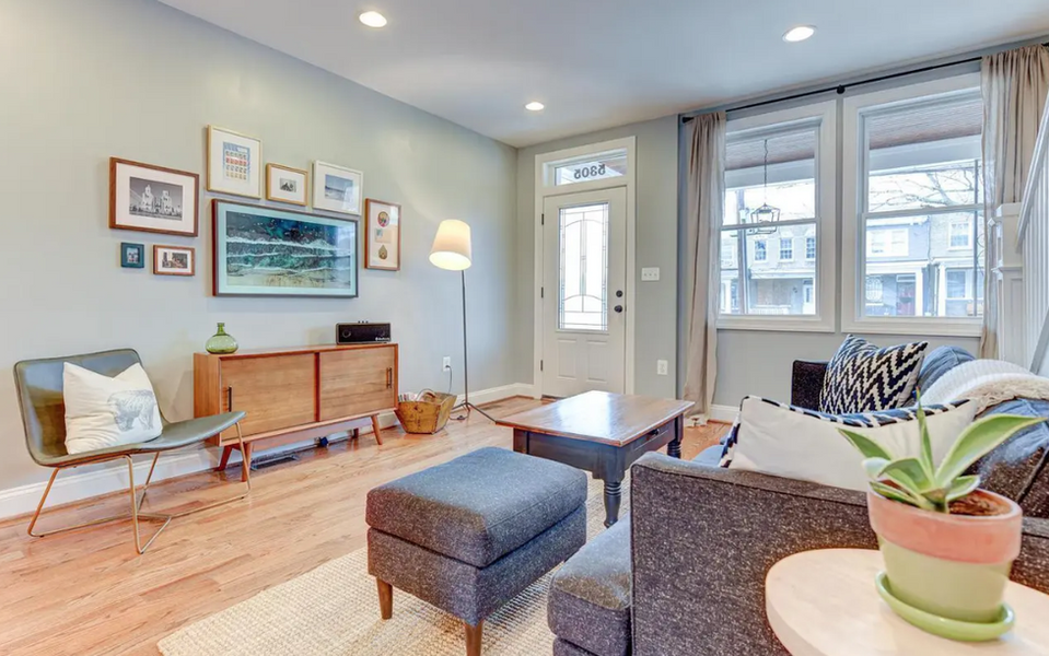 A spacious living room with large windows allowing for natural light throughout is a feature of this rental property in washington dc