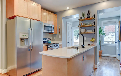 A charming kitchen with custom shelving and stainless steel appliances located in Brightwood Park, Washington DC