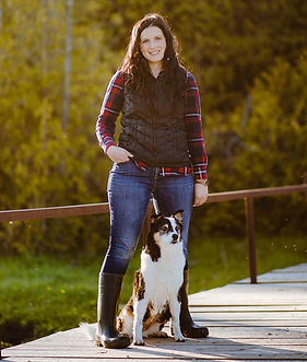 Dr. Heather Reinhardt standing with her dog at her feet.