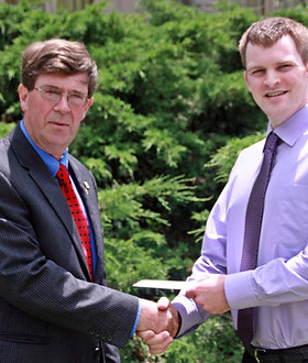 Dr. Matt Schieck receiving his award from Bill Herron.
