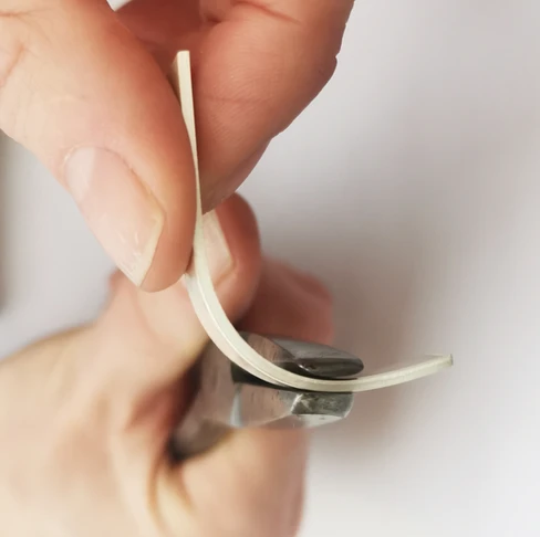 Piece of metal being turned into a ring shape using pliers