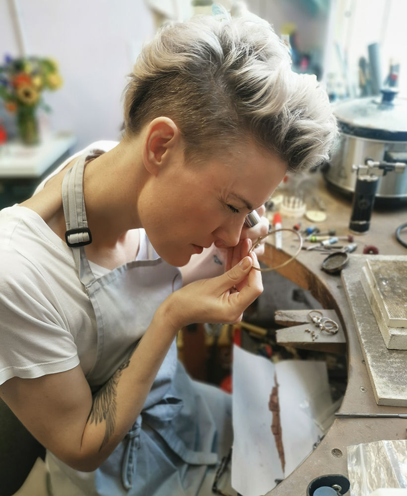 Jeweller Kate Smith using a loupe to check hallmarks on old jewellery ready for remodelling into a new ring