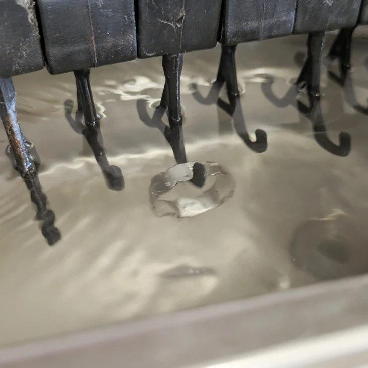Cleaning a silver ring using ultrasonic air waves to lift the grease