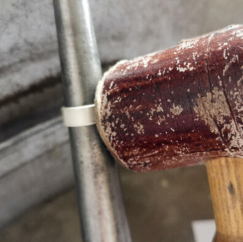 Using a ring mandrill and mallet to make a silver ring circular