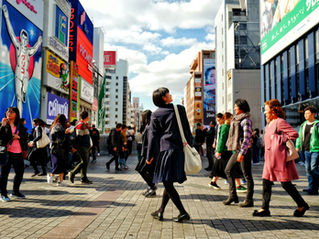 People walking down a busy road in Osaka