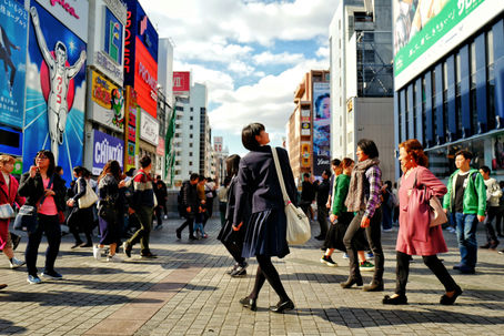 People walking down a busy road in Osaka
