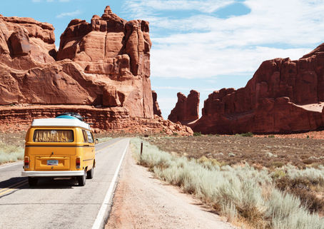 A van travelling across a deserting landscape