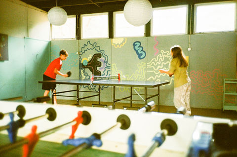 Dwie osoby grają w ping-ponga, piłkarzyki z przodu