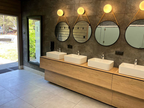 Nowoczesna łazienka z rzędem umywalek i okrągłych luster