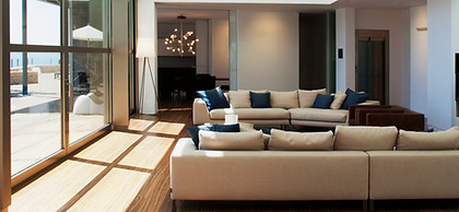 Living Room, brown couch, blue pillows, bright windows, wood floors, glass chandelier