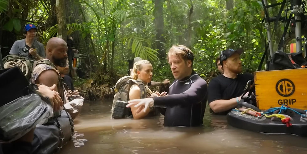 เบื้องหลังการถ่ายทำภาพยนตร์ Jurassic World: Rebirth ที่คลองหรูด (คลองน้ำใส) จังหวัดกระบี่ ผู้กำกับและทีมงานกำลังแนะนำทีมนักแสดงในฉากลุยน้ำกลางป่าดิบชื้น