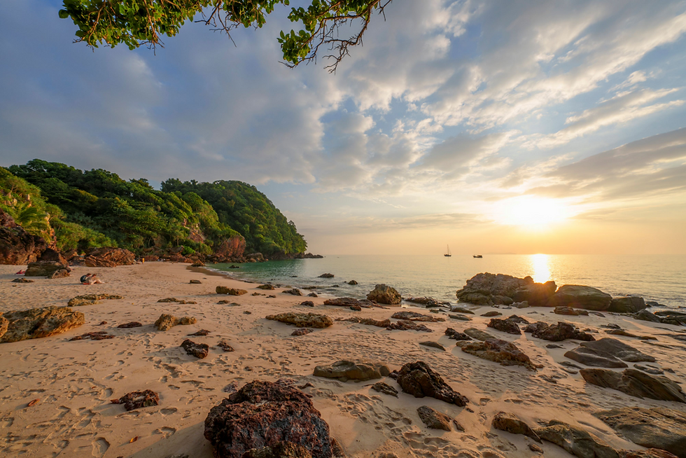 ภาพมุมสูงของหาดซันเซ็ทบนเกาะกระดาน จังหวัดตรัง ชายหาดสีขาวเงียบสงบ รายล้อมด้วยป่าทึบและหน้าผาหินปูน หนึ่งในฉากปิดท้ายของภาพยนตร์ Jurassic World: Rebirth