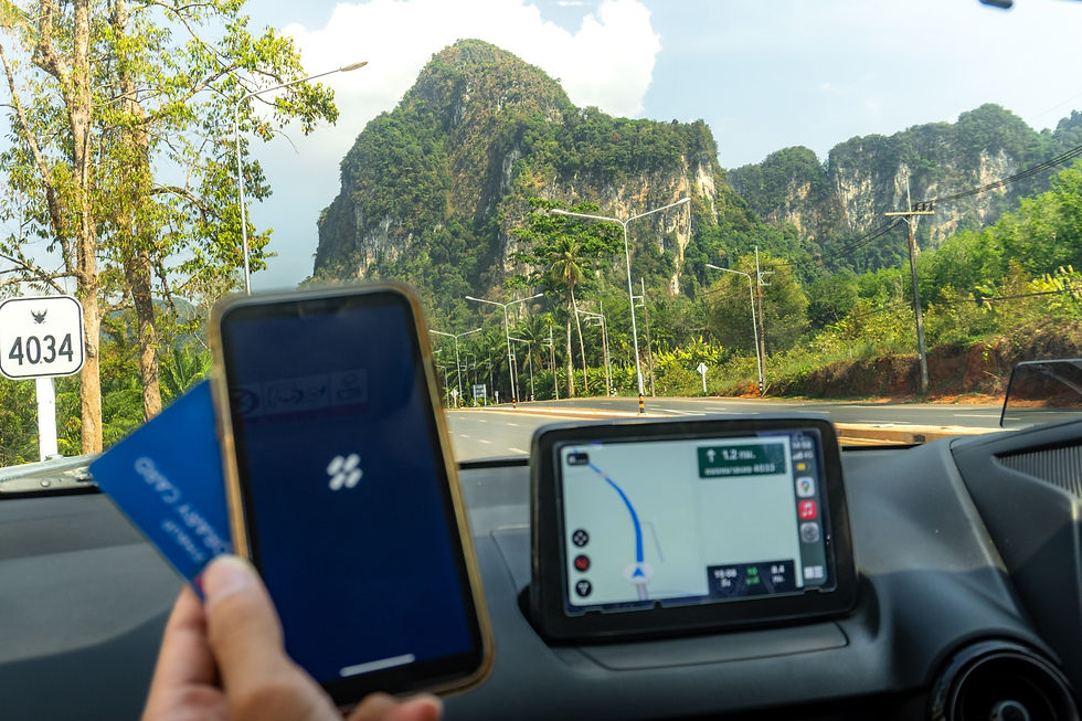 มุมมองจากภายในรถเช่า HAUP ขณะขับบนถนนสาย 4034 จังหวัดกระบี่ พร้อมหน้าจอ GPS และแอป HAUP บนสมาร์ตโฟน โปรโมตการเดินทางจากสนามบินสู่โลเคชันถ่ายทำ Jurassic World: Rebirth
