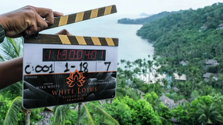 Film slate marked "The White Lotus Season 3 Thailand" held in front of a tropical island view in Koh Samui.