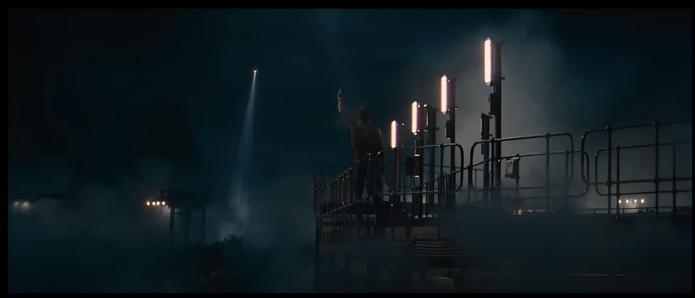 ฉากกลางคืนสุดเข้มข้นจากภาพยนตร์ Jurassic World: Rebirth ถ่ายทำที่เขาขนาบน้ำ จังหวัดกระบี่ ชายคนหนึ่งยืนบนแท่นเหล็กท่ามกลางหมอกหนาและไฟส่องสว่าง ขณะเฮลิคอปเตอร์บินเข้ามาแต่ไกล