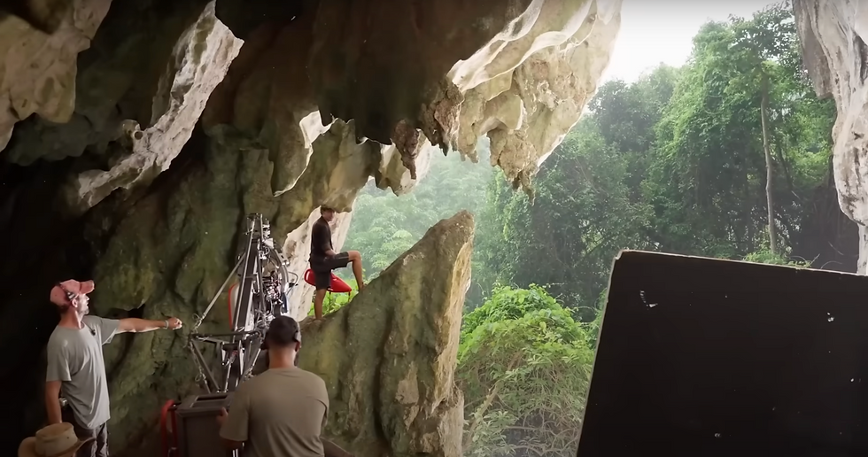 เบื้องหลังการถ่ายทำภาพยนตร์ Jurassic World: Rebirth ที่ถ้ำโต๊ะหลวง จังหวัดกระบี่ ทีมงานกำลังติดตั้งอุปกรณ์ถ่ายทำภายในถ้ำหินปูนขนาดใหญ่ ที่มองออกไปเห็นวิวป่าฝนเขตร้อนด้านนอก