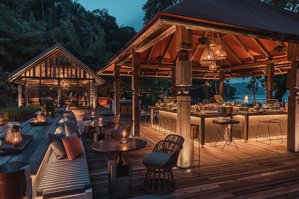 โซนรับประทานอาหารกลางแจ้งของร้านตาไข่ ภูเก็ต พร้อมศาลาไม้ โคมไฟ และวิวทะเลยามเย็นในบรรยากาศอบอุ่น