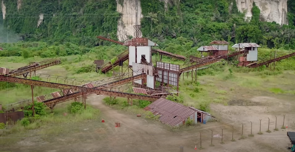 โรงงานเหมืองร้างพร้อมสายพานลำเลียงเก่าและอาคารสนิมจับ ตั้งอยู่ท่ามกลางป่าร้อนชื้นในพื้นที่นายเหมือง ตำบลทับปริก จังหวัดกระบี่ หนึ่งในโลเคชันถ่ายทำภาพยนตร์ Jurassic World: Rebirth