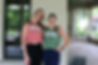 Two women smiling with their arms around each other wearing SocialMotion shirts