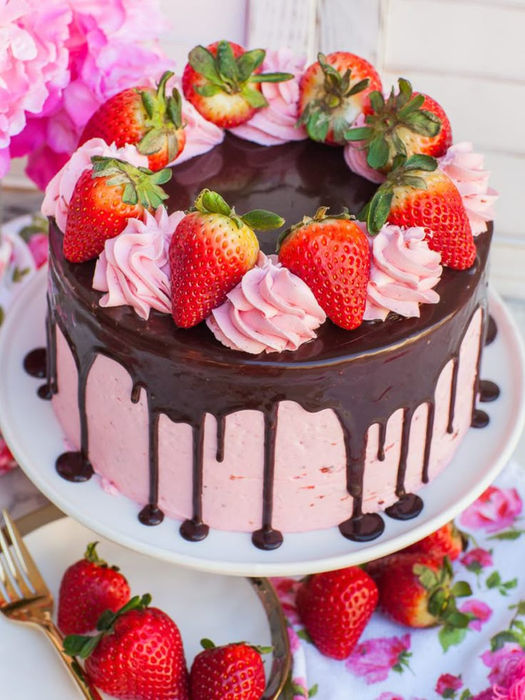 Strawberry cake with chocolate frosting and fresh strawberries on top.