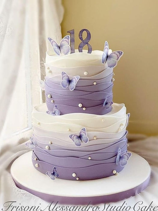 Two-tiered purple cake with butterflies and the number 18. Treasure Moments Cake