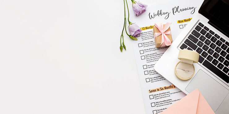 imagem aérea de um notebook com um porta alianças e um papel de checklist para casamento